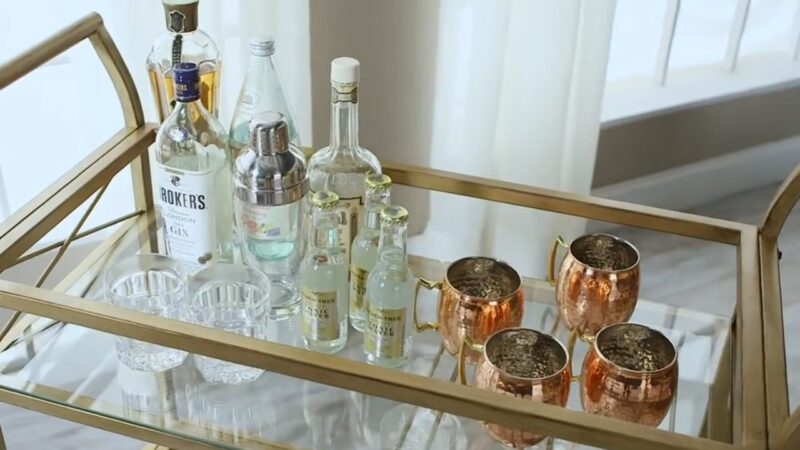 A Stylish Bar Cart in A Living Room, Featuring Various Bottles of Liquor, Glassware, and Cocktail Accessories